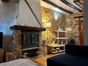 a living room with a fireplace in a stone wall at Rural Stone House with wood fireplace in Pinell de Bray