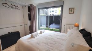 ロマンヴィルにあるL'Écrin Parisien - Proche Métro -Direct Paris - 4 personnesのベッドと大きな窓のある寝室 +16枚の写真