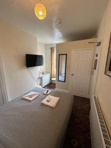 a bedroom with a bed with two napkins on it at Winston House Guesthouse in Bridlington +74 photos