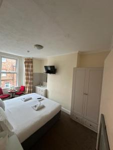 a hotel room with a bed and a tv at Winston House Guesthouse in Bridlington