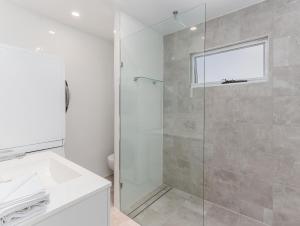 キングスクリフにあるRelax on Marine Parade, 2 Bedroom Apartmentのシャワーと洗面台を備えた白いバスルーム +8枚の写真