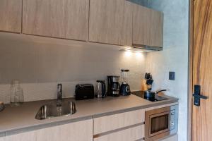 a kitchen counter with a sink and a microwave at Top Location Studio with Rooftop Pool, Gym and Padel Court in Tulum