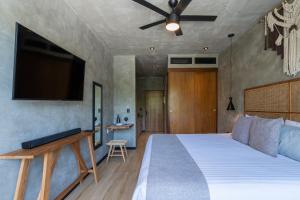 a bedroom with a bed and a flat screen tv at Top Location Studio with Rooftop Pool, Gym and Padel Court in Tulum