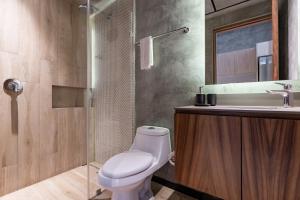 a bathroom with a toilet and a sink and a shower at Top Location Studio with Rooftop Pool, Gym and Padel Court in Tulum +35 photos