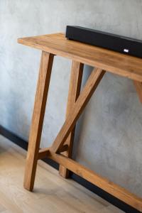 a wooden table with a television on top of it at Top Location Studio with Rooftop Pool, Gym and Padel Court in Tulum