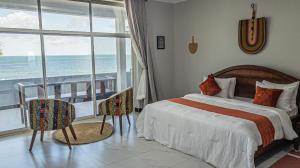 乌罗阿Spacious Beachfront Condo -AC - WIFI, Uroa Escape Zanzibar的一间带床的卧室，可欣赏海景
