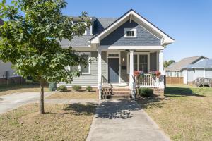 a white house with a tree in front of it at Fam-Biz Friendly 3BD with Fire pit & BBQ - Downtown in Raleigh