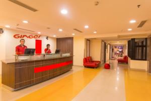 a lobby with two people standing at a counter at Ginger Chennai - Vadapalani in Chennai