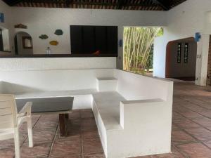 a white bench in a room with a television at Casa estilo suizo cerca del mar in Tierra Mala