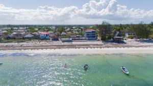 乌罗阿Spacious Beachfront Condo -AC - WIFI, Uroa Escape Zanzibar的两艘船在水面上享有海滩的空中景色
