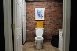 a bathroom with a brick wall and a white toilet at The love loft on the waterfree parking downtown in Troy +16 photos