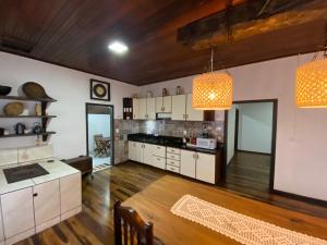a large kitchen with white cabinets and a wooden floor at Sítio Nono Luiz in Benedito Novo