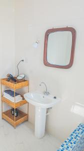乌罗阿Spacious Beachfront Condo -AC - WIFI, Uroa Escape Zanzibar的带水槽和镜子的浴室