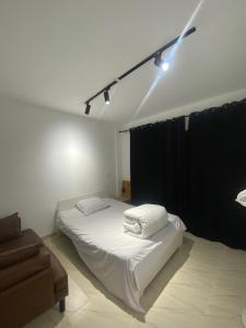 a bedroom with a white bed and a black curtain at Butterfly in Madinaty