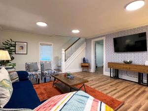 Una sala de estar con un sofá azul y un televisor de pantalla plana. en Quaint Renovated Single Family, en Matawan