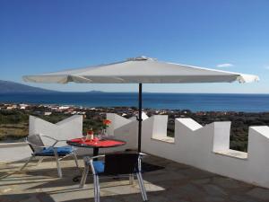 a table and chairs with an umbrella on a roof at Kastro Villas in Marathokampos +9 photos