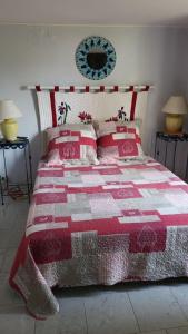a bedroom with a bed with a red and white quilt at Emplacement exceptionnel pour 4 personnes in Boulouris-sur-Mer