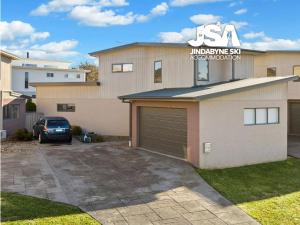 贝瑞黛尔Berridale Bliss的车道上设有车库和停车场的房子