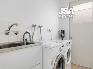a kitchen with a washing machine and a sink at Berridale Bliss in Berridale