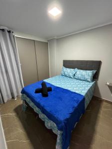 ein Schlafzimmer mit einem blauen Bett und einem schwarzen Hut darauf in der Unterkunft Flat Alto Padrão 4 in Campina Grande + 10 Fotos