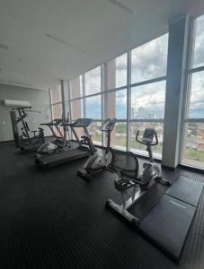 ein Fitnessraum mit mehreren Kardiogeräten in einem Zimmer mit Fenstern in der Unterkunft Flat Alto Padrão 4 in Campina Grande