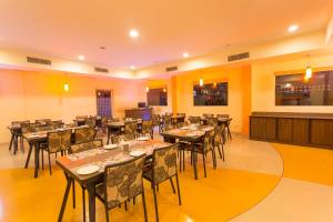 a restaurant with tables and chairs in a room at Ginger Pune - Pimpri in Pune