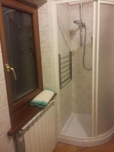 W łazience znajduje się prysznic ze szklanymi drzwiami. w obiekcie Agriturismo La Buca w mieście Cutigliano