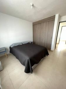 a bedroom with a black bed in a room at Alojamiento en León in Santa Gertrudis