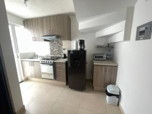 a kitchen with a black refrigerator and a stove at Alojamiento en León in Santa Gertrudis