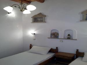 2 letti in una camera con pareti bianche di Kastro Villas a Marathokampos
