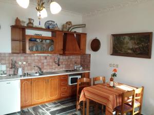 a kitchen with wooden cabinets and a table with a table cloth at Kastro Villas in Marathokampos