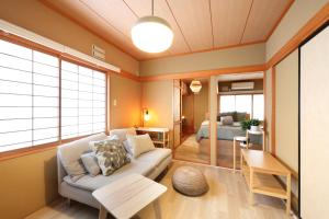 a living room with a couch and a bedroom at プレジール弘前101 in Hirosaki