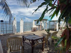 a table and chairs on a beach with the ocean at Sky Beach budget rooms in Catmon