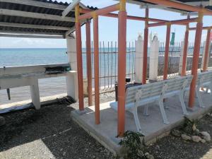 a bench sitting under a pavilion at the beach at Sky Beach budget rooms in Catmon