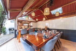 a dining room with a wooden table and chairs at Fat Lips Surf Lodge in General Luna