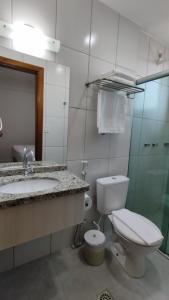 a bathroom with a toilet and a sink at Golden Dolphin Supreme in Caldas Novas