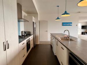 a large kitchen with white cabinets and a sink at Blae Loch - Lake Tekapo in Lake Tekapo +12 photos