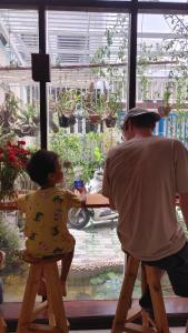 a man and a little girl sitting on stools at Phe's House in Da Nang