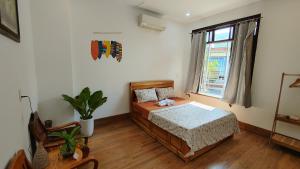 a bedroom with a bed and a window at Phe's House in Da Nang