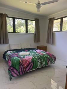 a bed with a colorful comforter in a bedroom at Eryns Retreat in Avarua