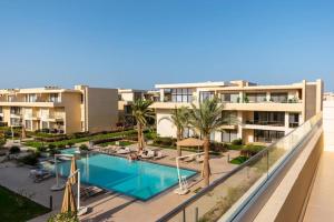 an apartment with a swimming pool and palm trees at El Gouna -G-cribs B6 in El Gouna