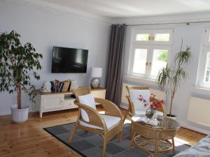 a living room with a table and chairs and a tv at Ostseewelle Comfortable holiday residence in Middelhagen