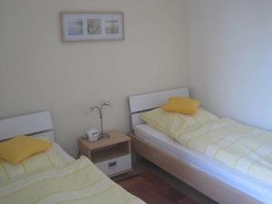 two beds with yellow pillows in a room at Poseidon in the Amrumer Welle in Wittdün