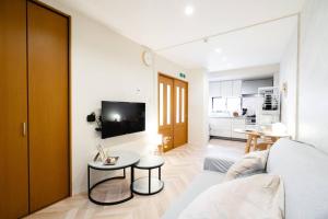 a living room with a couch and a table at 天下茶屋vii 忙しい旅行中も ゆったりした時間を過ごせるお部屋 お勧めコーヒーと共に in Osaka