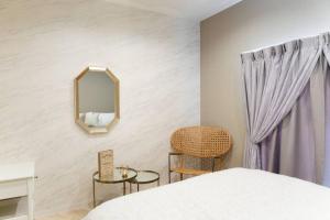 a bedroom with a bed and a mirror and a chair at 天下茶屋vii 忙しい旅行中も ゆったりした時間を過ごせるお部屋 お勧めコーヒーと共に in Osaka