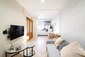 a living room with a couch and a table at 天下茶屋vii 忙しい旅行中も ゆったりした時間を過ごせるお部屋 お勧めコーヒーと共に in Osaka