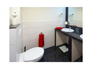 a bathroom with a toilet and a sink at Holiday apartment Balkenstek in Norddeich