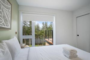 a bedroom with a white bed and a large window at Ultra Luxurious Modern Chalet Private Jacuzzi in La Conception