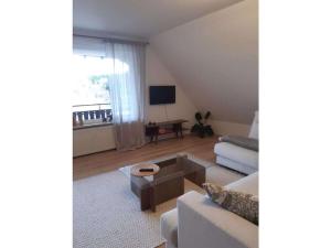 a living room with a couch and a coffee table at Comfortable holiday residence on the lake in Herrischried