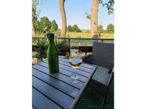 a bottle of wine and a glass on a table at Ranchhouse Dogs and horses welcome in Aurich